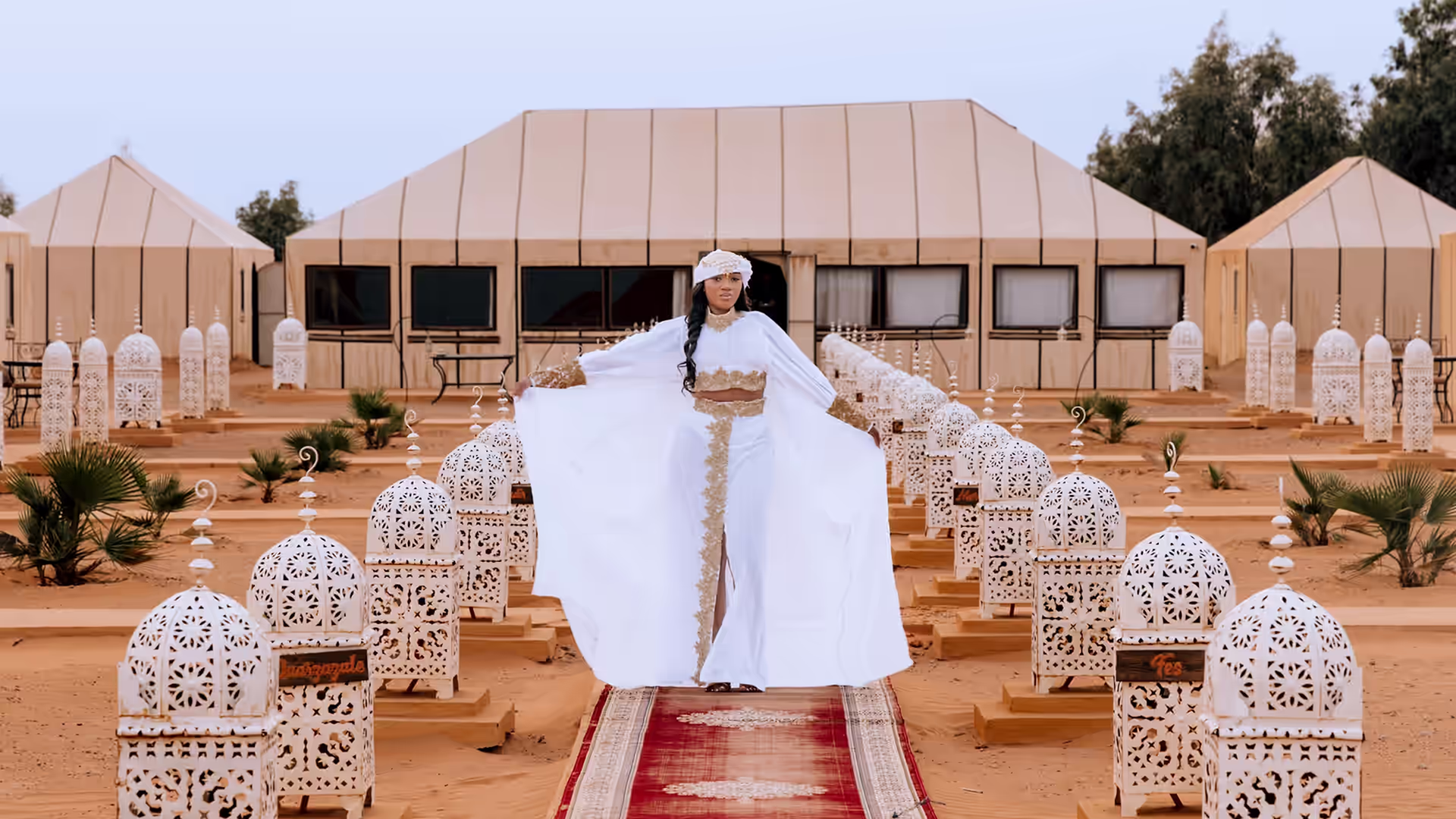 Campamento de lujo en el desierto de Merzouga con haimas blancas y camino de alfombras