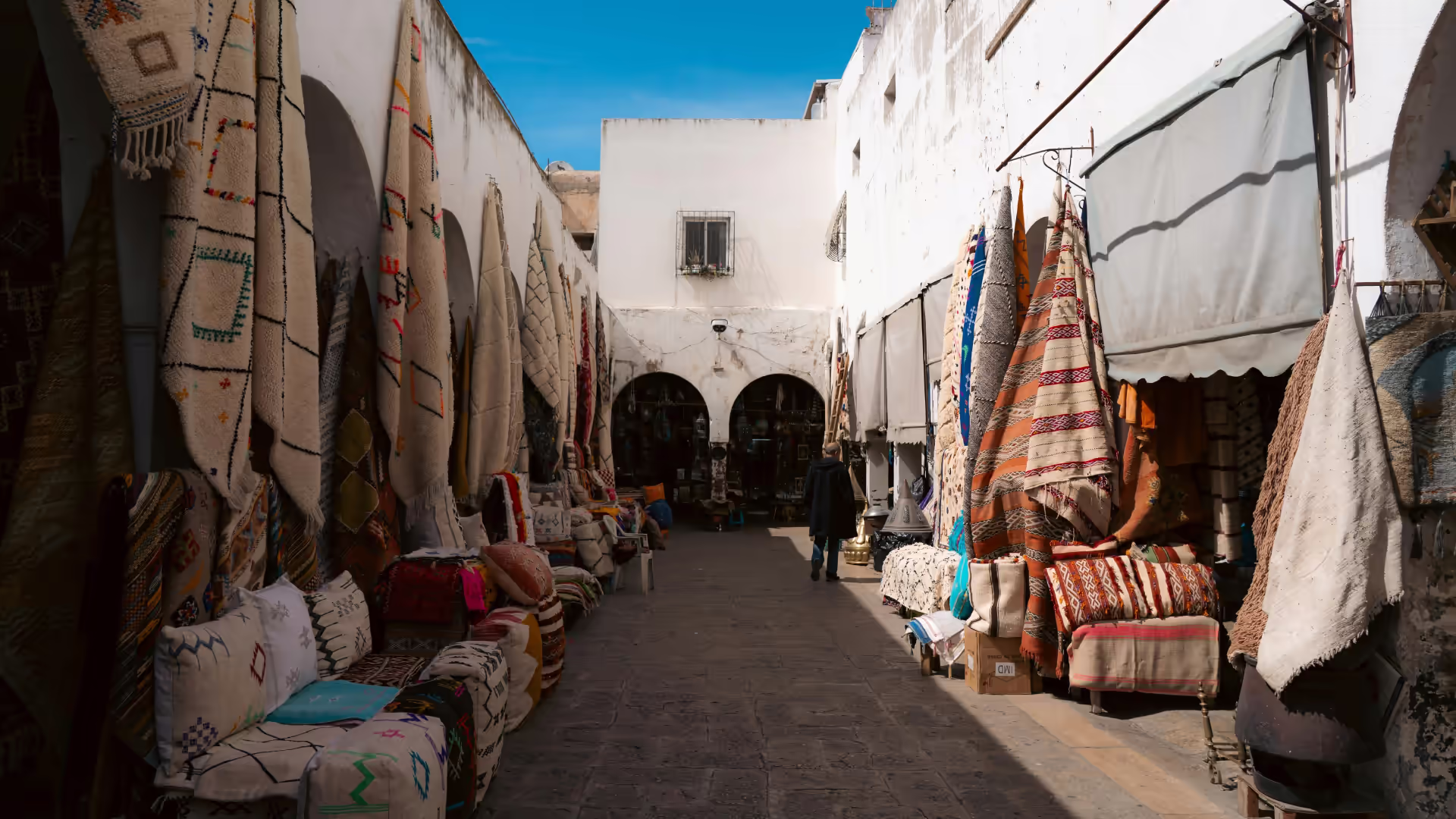 Callejón de mercado tradicional con textiles de colores colgados